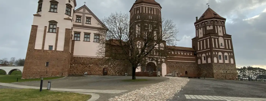Mir Castle's red brick towers at the end of a cobbled path, Belarus