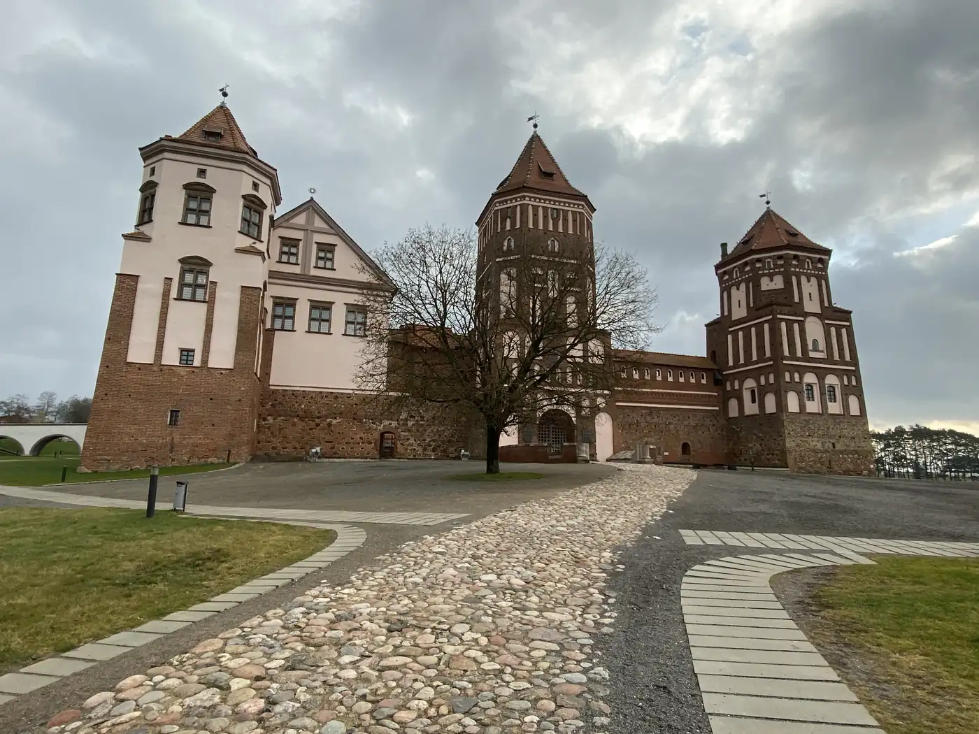 Mir Castle's red brick towers at the end of a cobbled path, Belarus