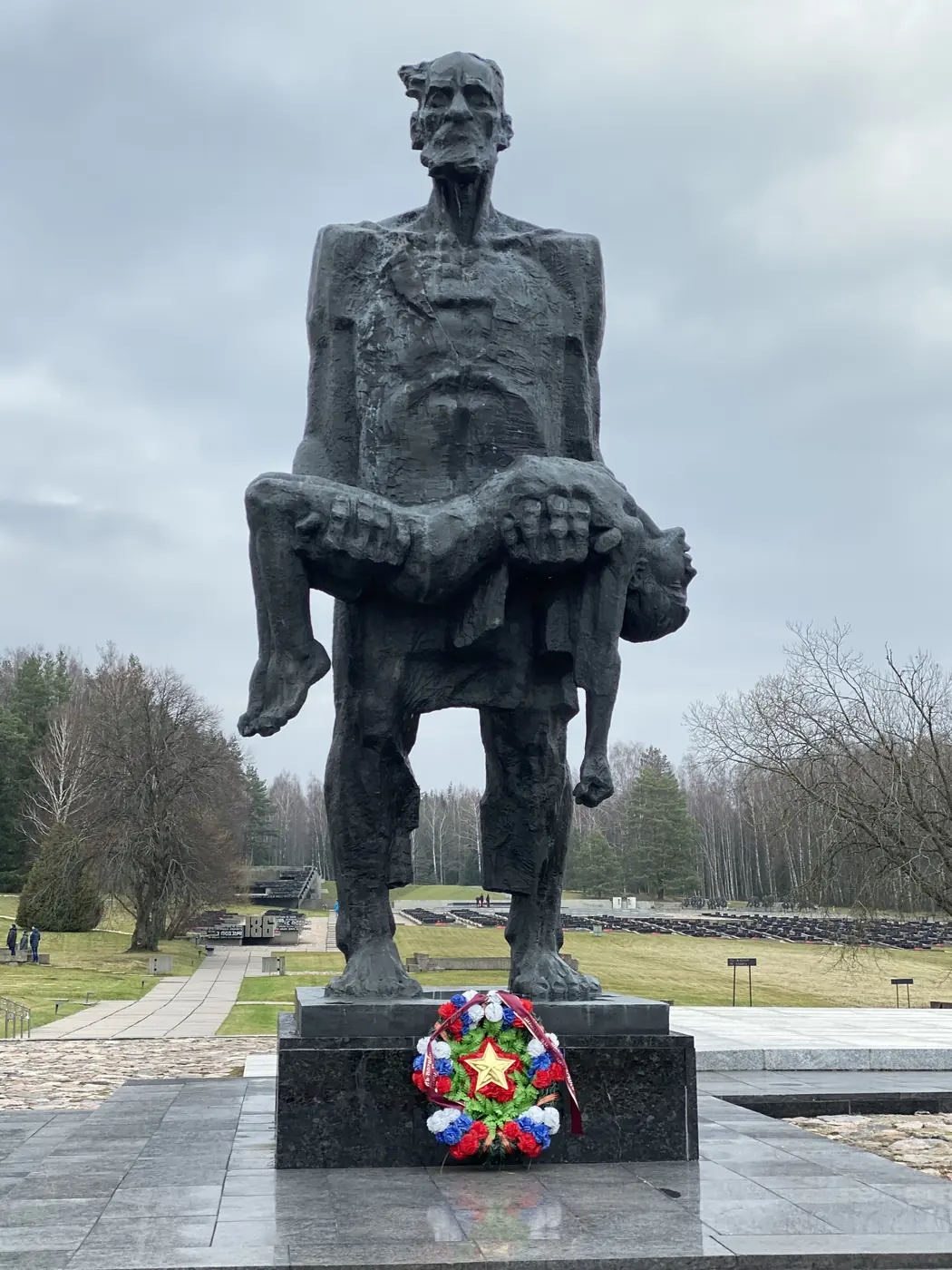 The Unbowed Man statue at the Khatyn memorial, with red carnations at its base