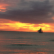 Sunset over White Beach, a paraw sailboat on the horizon