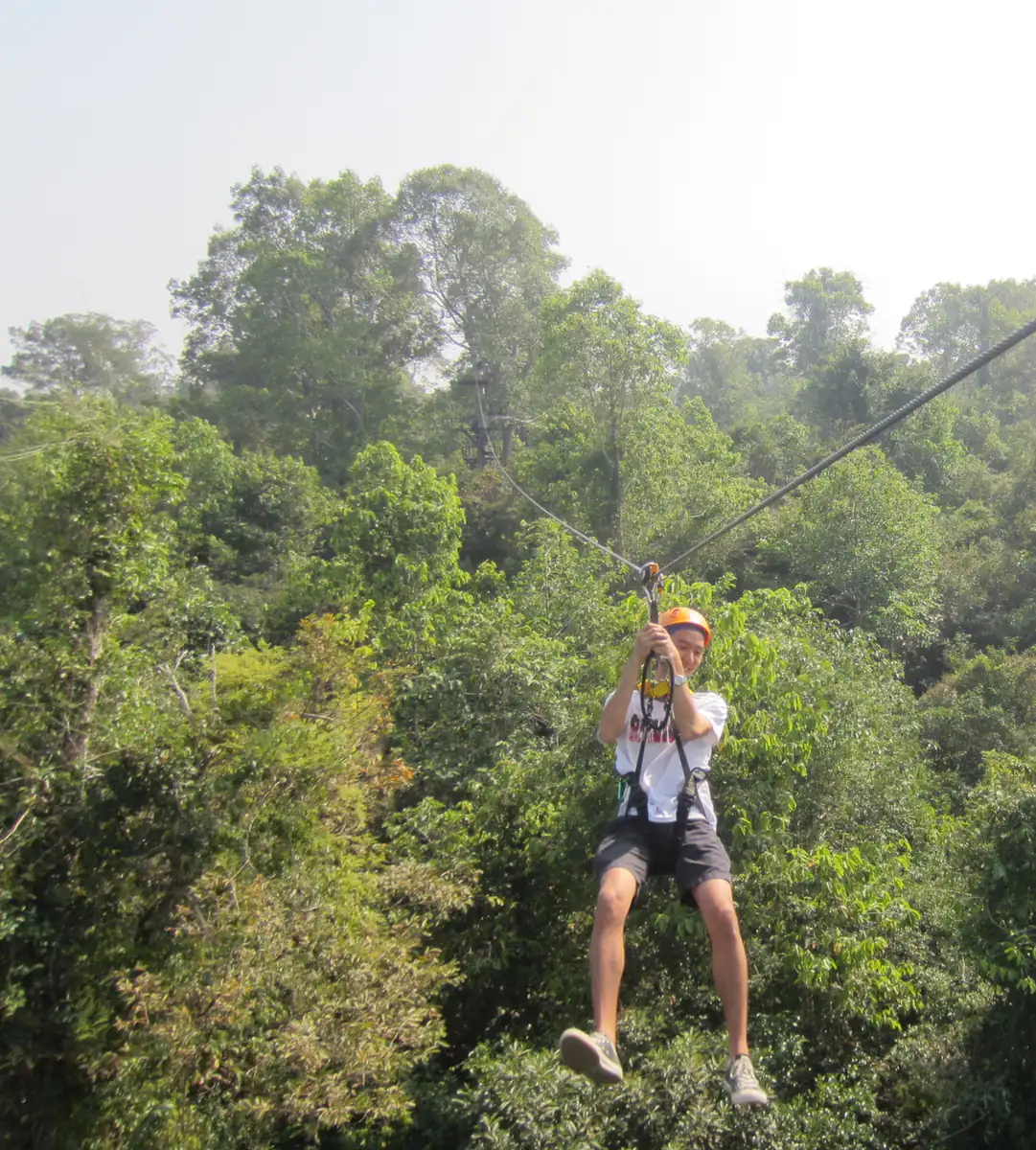 A rider on the zip line over the forest near Angkor