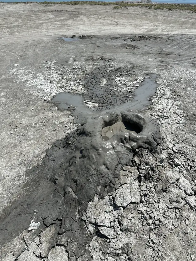 A small mud volcano with cracked grey mud near Gobustan, Azerbaijan
