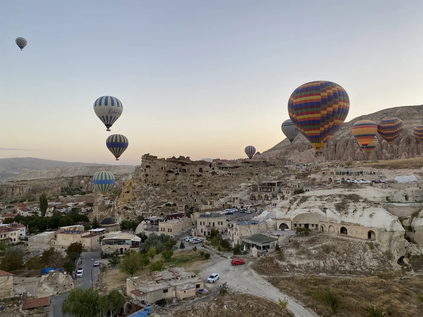Balloons rising over a rock-cut village in Cappadocia