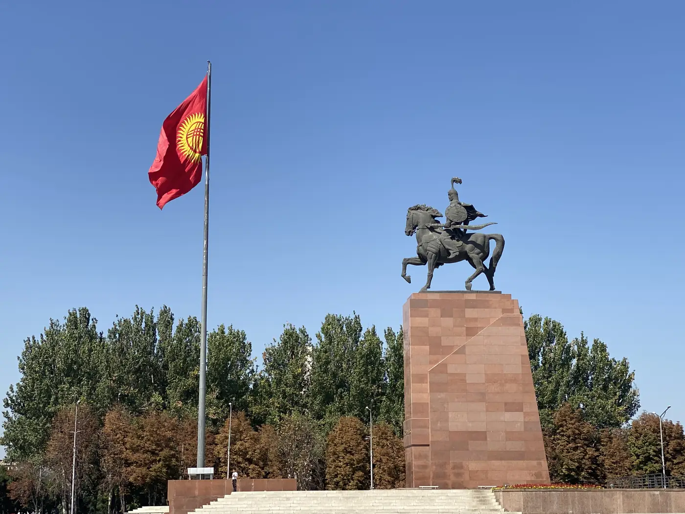 Manas equestrian statue beside the Kyrgyz flag in Bishkek