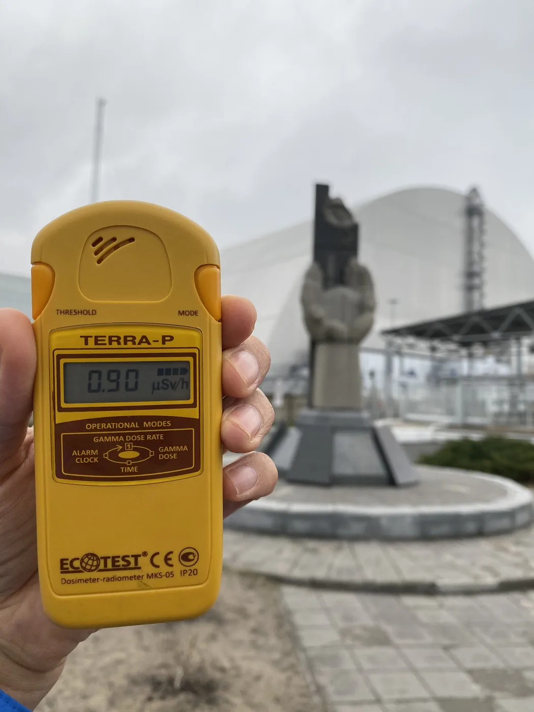 A dosimeter reading 0.90 at the memorial in front of the arch over Reactor 4