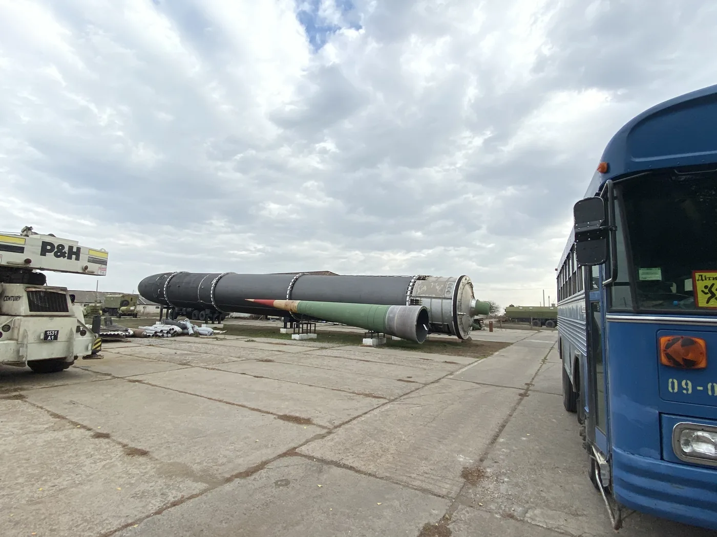 A Soviet missile on its side beside a tour bus at the Strategic Missile Forces Museum