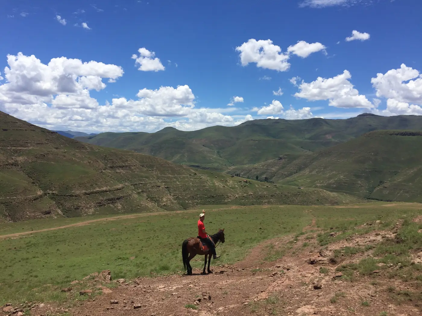 A tiny rider in a green valley