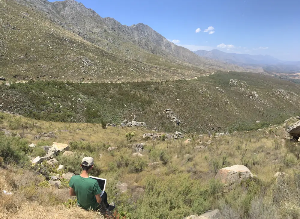 Working on a laptop on a hillside, South Africa