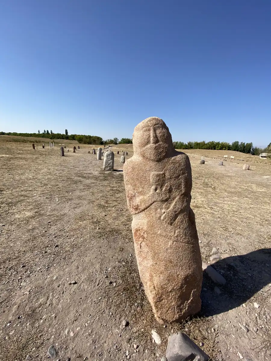 A carved stone balbal grave marker beside the Burana Tower