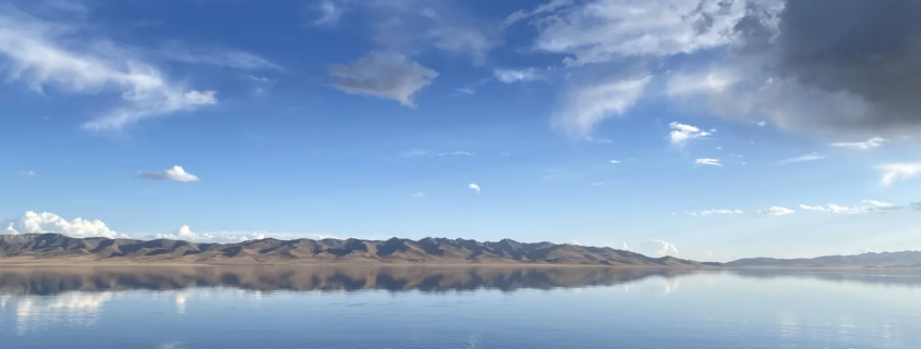 Song-Kol Lake reflecting the sky and mountains at dusk, Kyrgyzstan