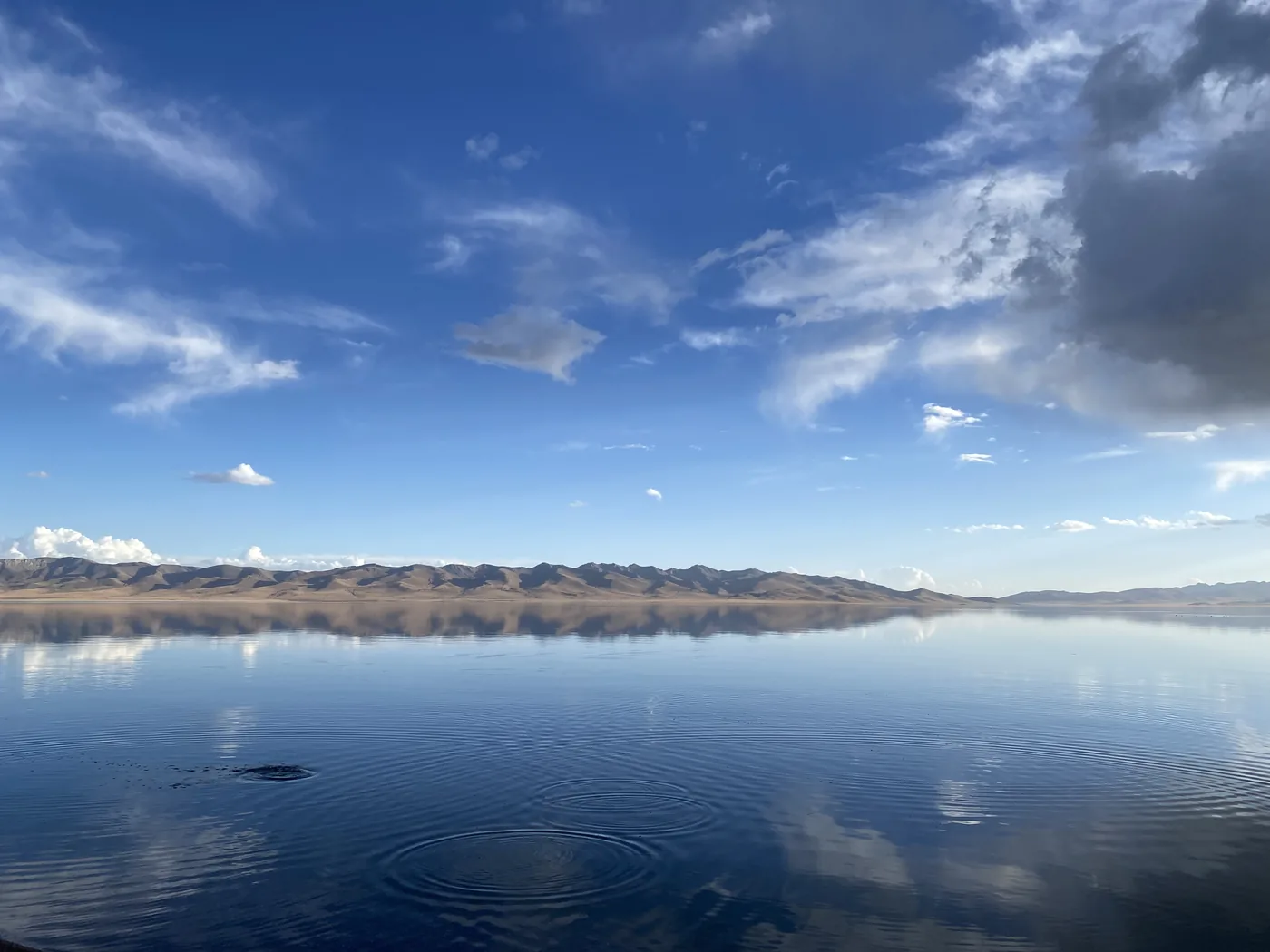 Song-Kol Lake reflecting the sky and mountains at dusk, Kyrgyzstan