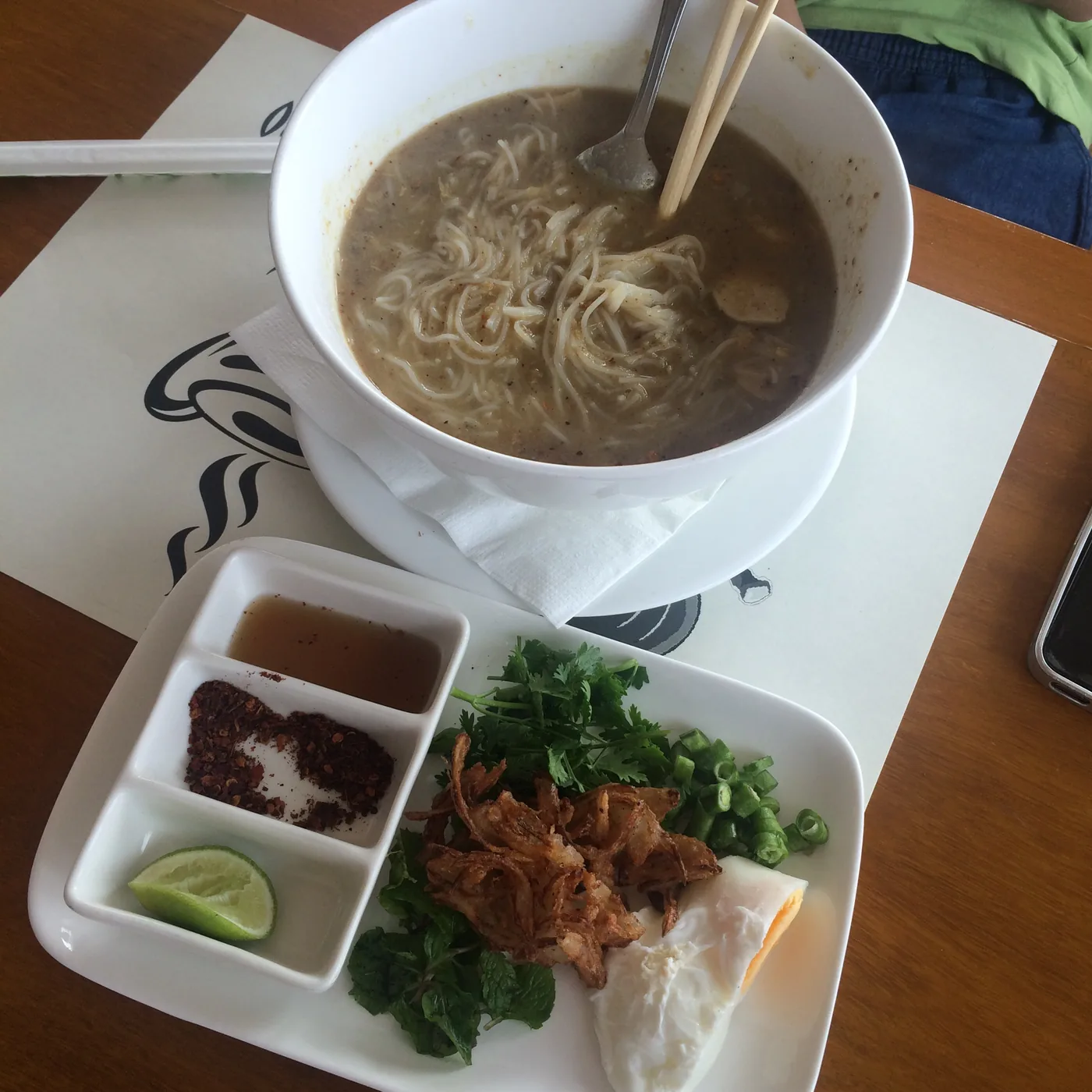 A bowl of noodle soup with its condiments in Yangon