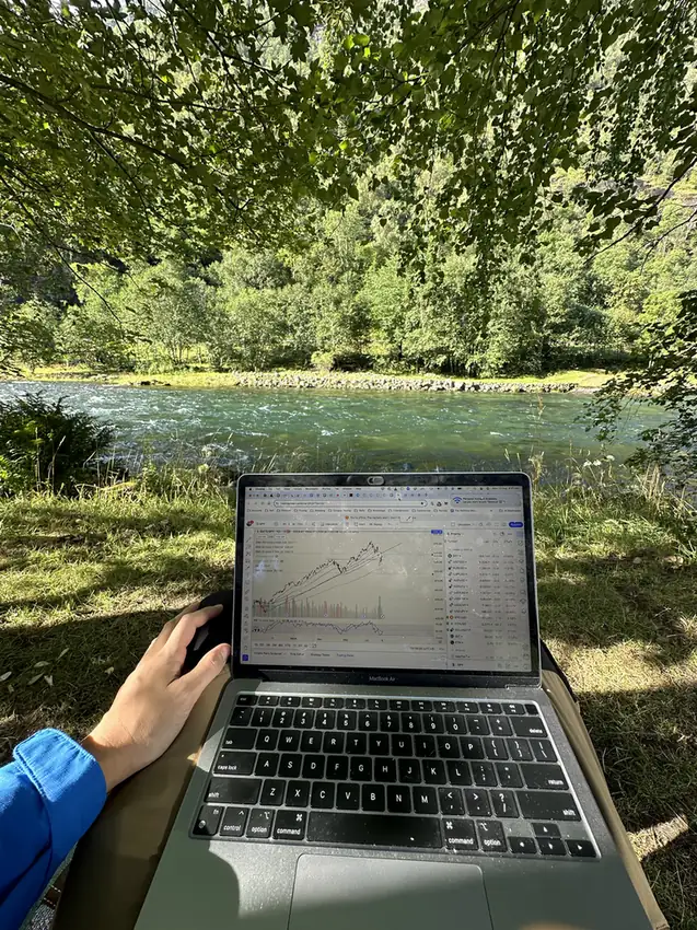Laptop with a chart, by the campsite river