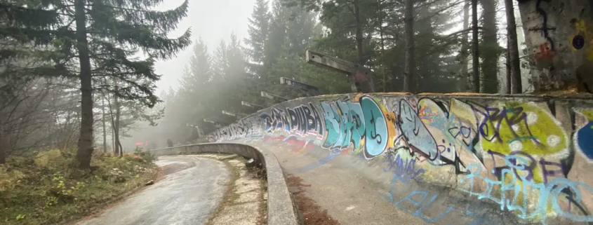 A graffiti-covered bend of the 1984 Olympic bobsleigh track on Mount Trebevic in fog
