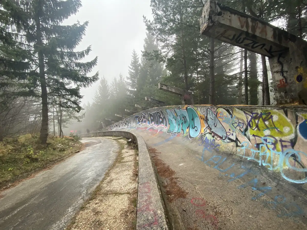A graffiti-covered bend of the 1984 Olympic bobsleigh track on Mount Trebevic in fog