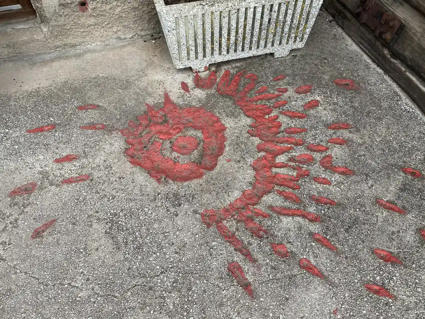 A Sarajevo rose, a shell scar filled with red resin, on the ground at the Tunnel of Hope
