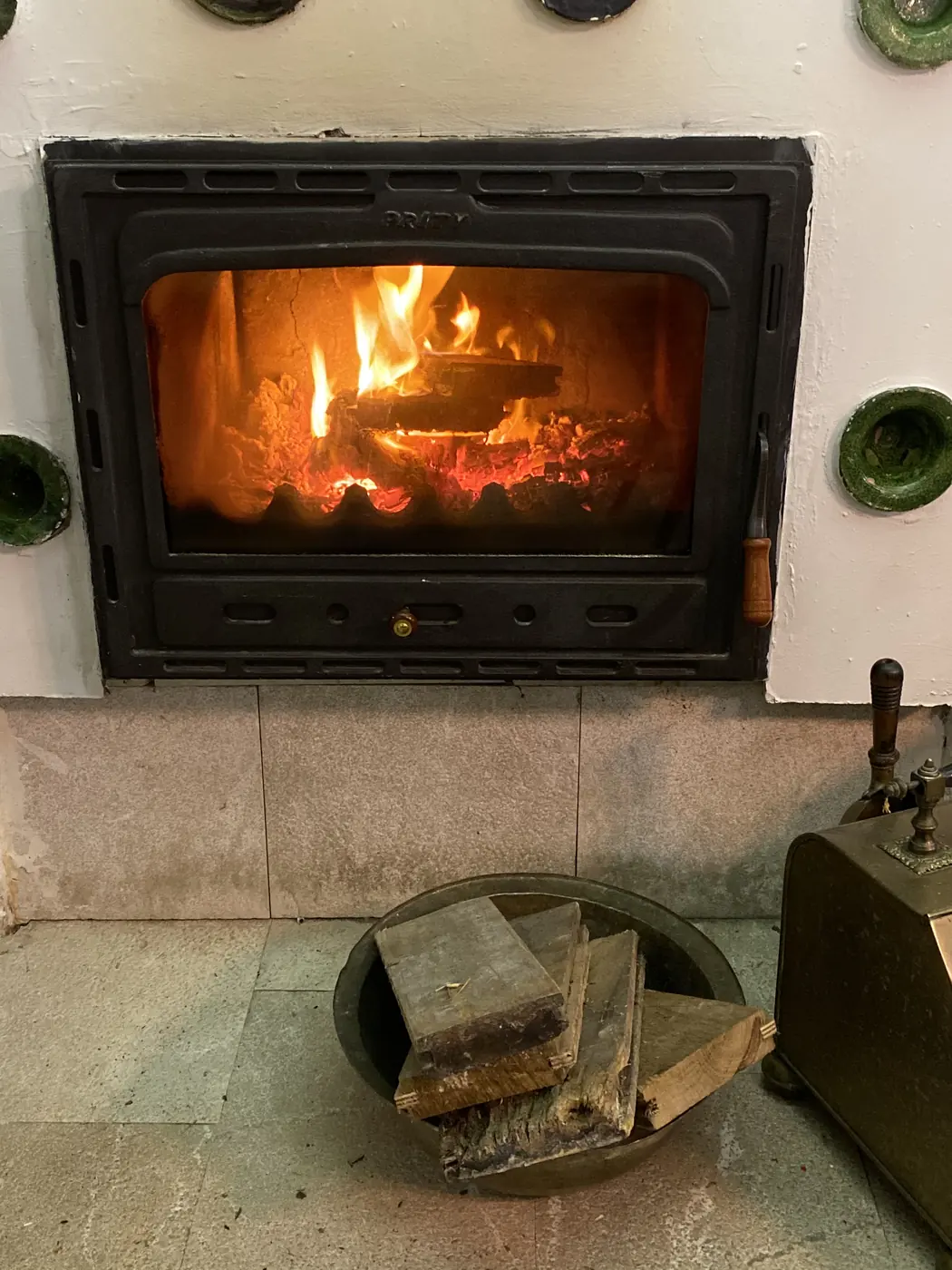 A wood fire burning in a tiled stove inside the Spite House, Sarajevo