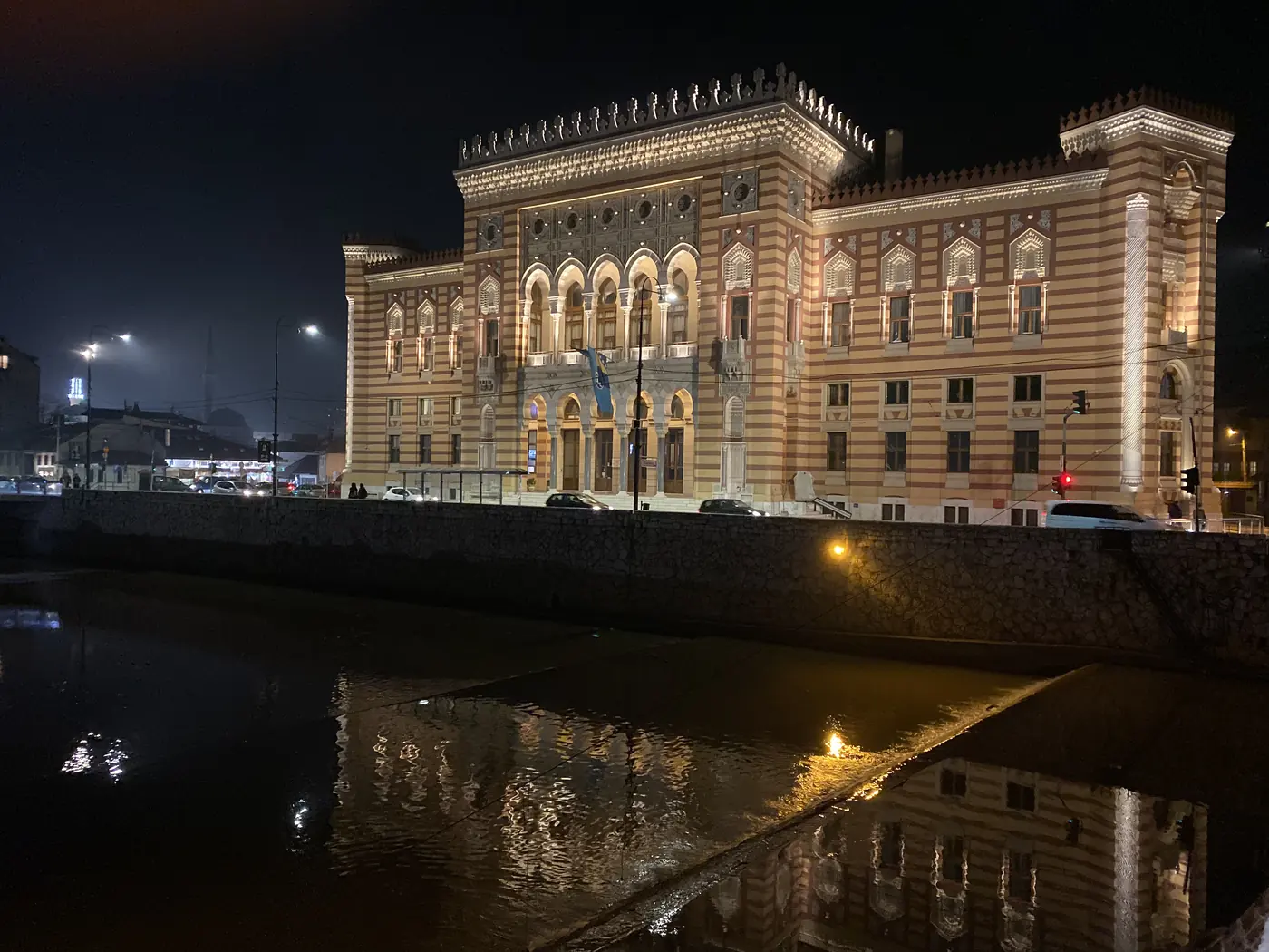 Sarajevo City Hall, the Vijecnica, lit up at night over the Miljacka river