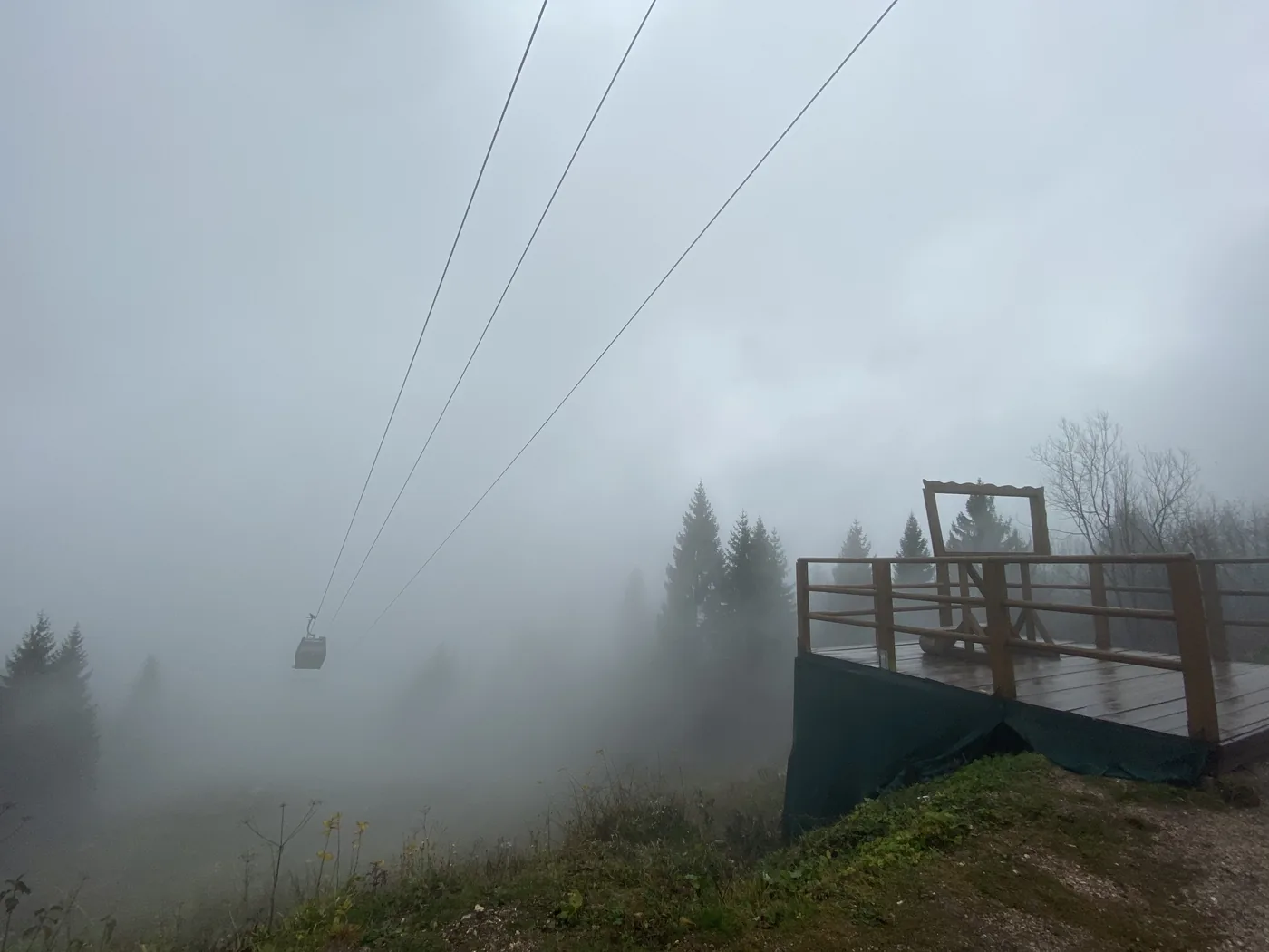 The Trebevic cable car passing overhead in thick fog above Sarajevo