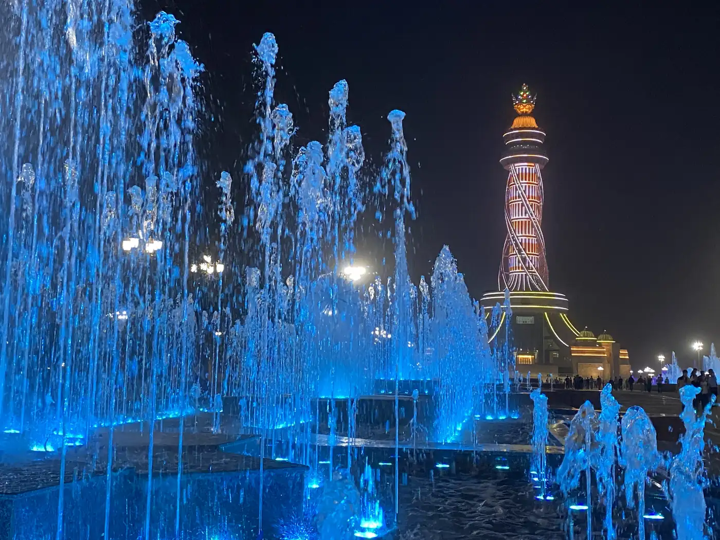 Blue dancing fountains in front of the Istiklol tower in Dushanbe at night