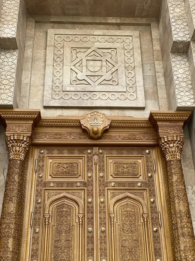 Carved gold wooden doors at the base of the Istiklol tower, Dushanbe