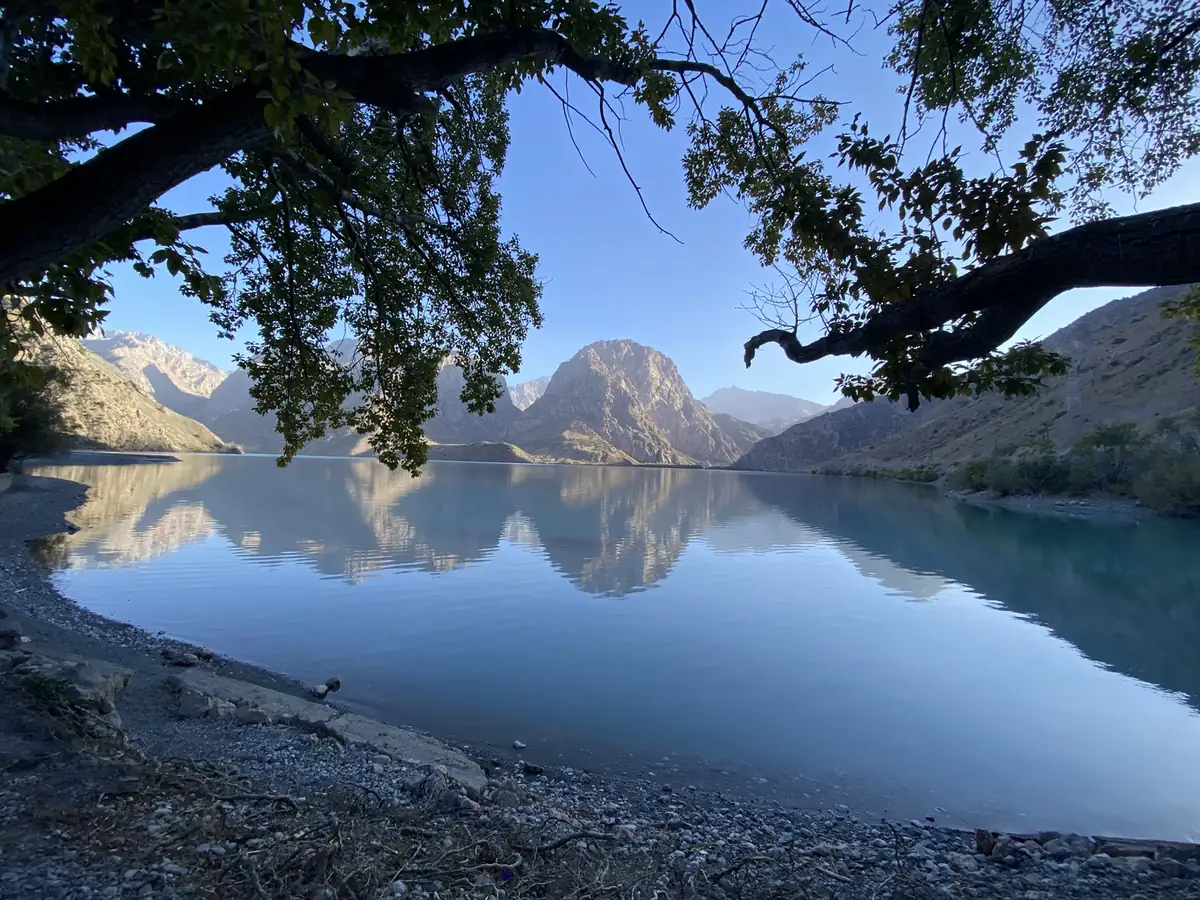 Iskanderkul lake reflecting the Fann Mountains in still water, Tajikistan