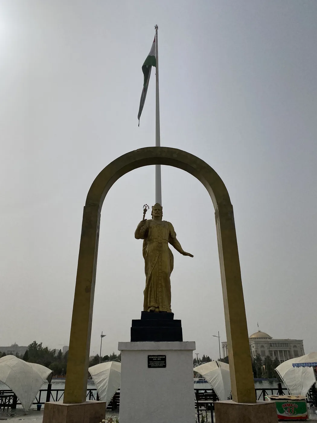 The gold statue of the poet Rudaki under an arch in Dushanbe