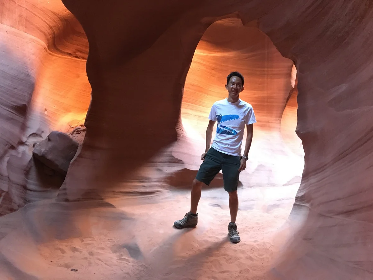 Spencer inside Antelope Canyon, with the sandstone walls glowing orange