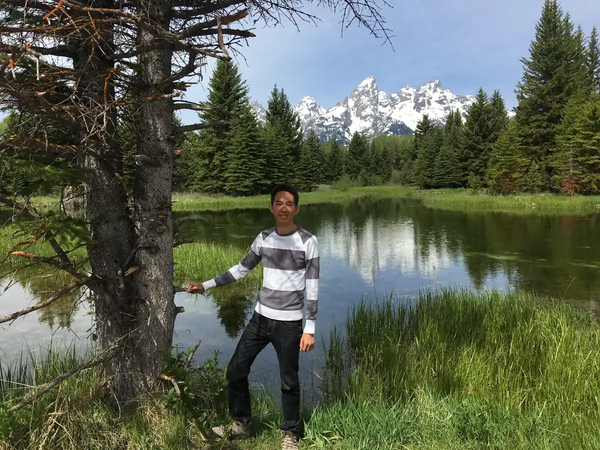 Spencer by a pond below the snow-capped Teton range