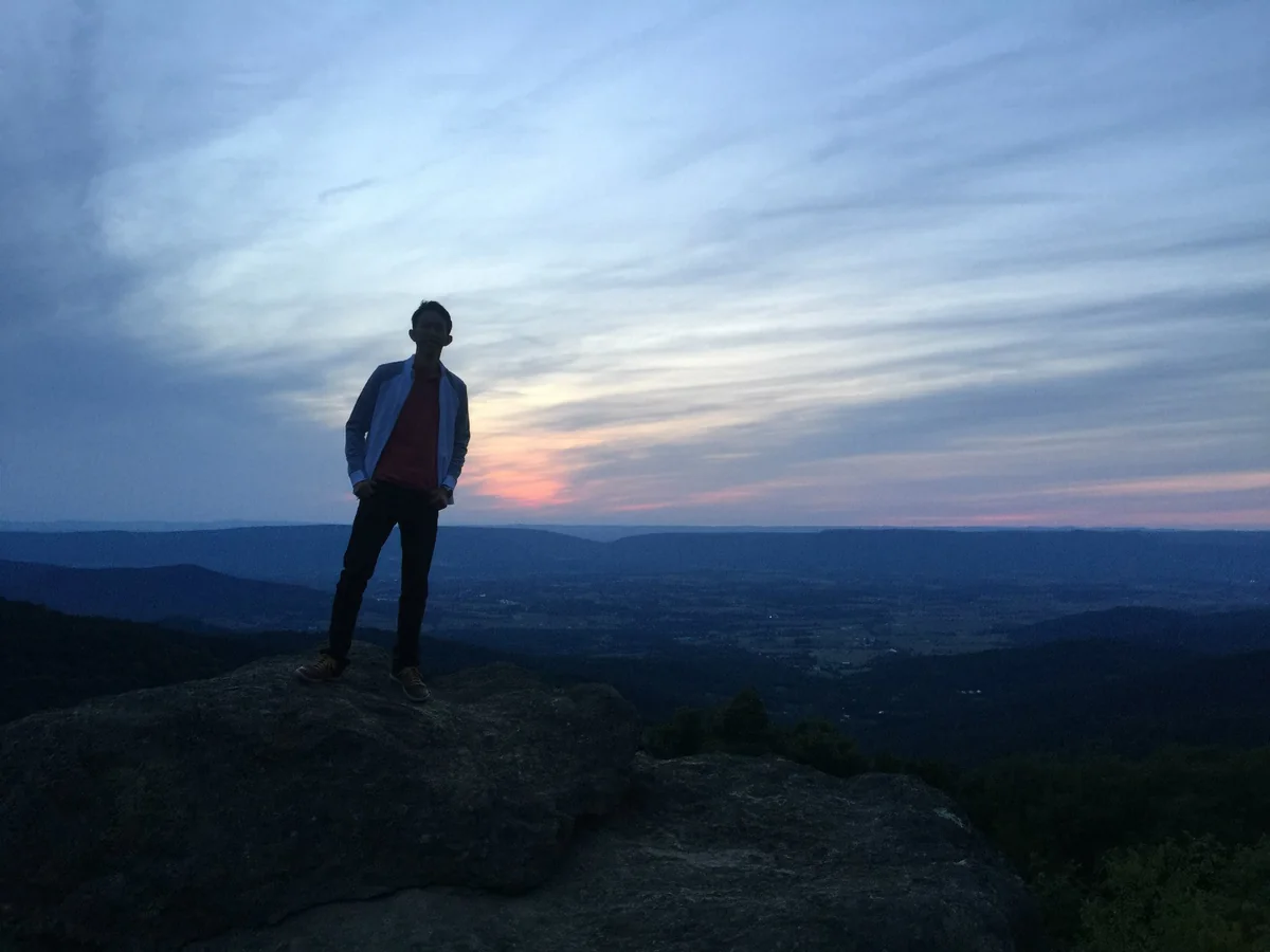 Spencer silhouetted on a rock at sunset in Shenandoah National Park