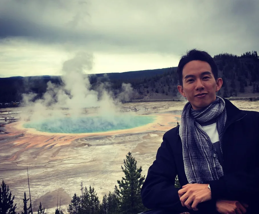 Spencer at Grand Prismatic Spring in Yellowstone, with steam rising behind