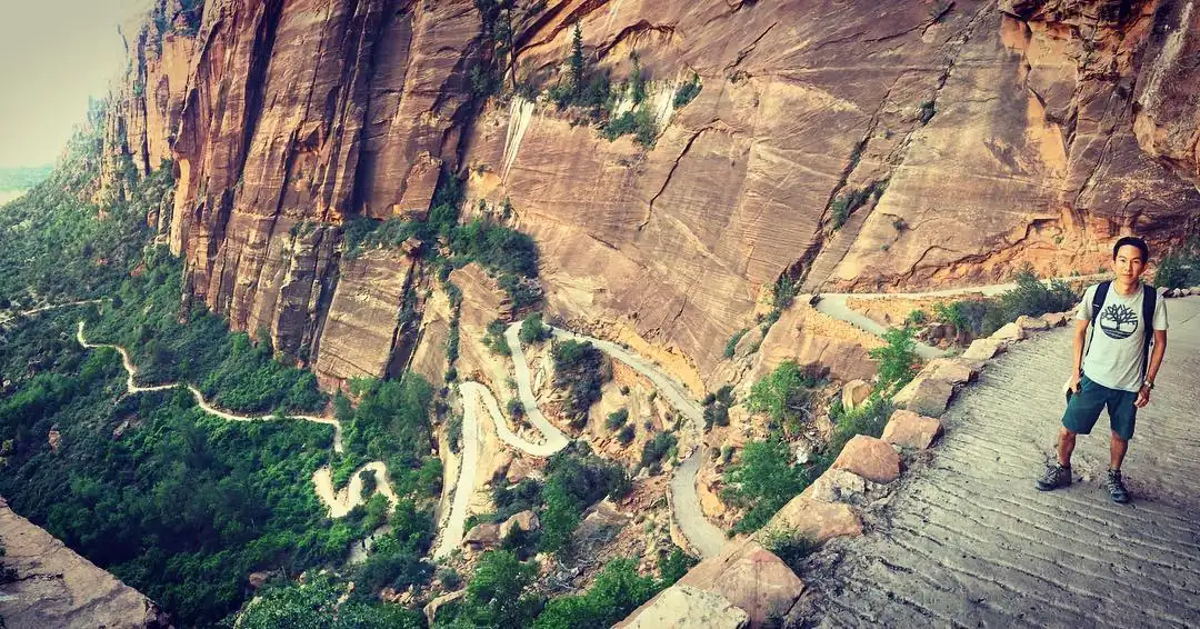 Spencer on a cliff trail in Zion, with the switchbacks far below